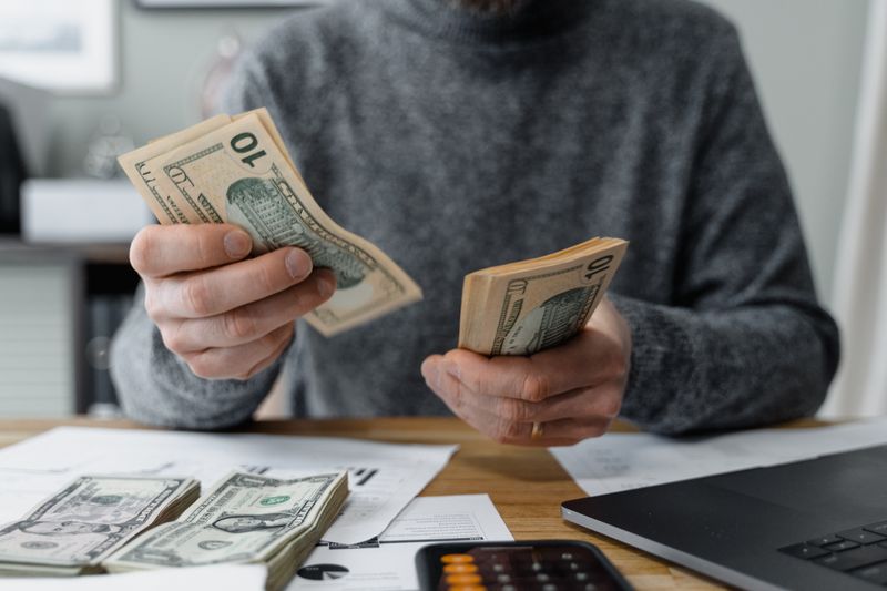 Hands counting cash from legal cannabis sales