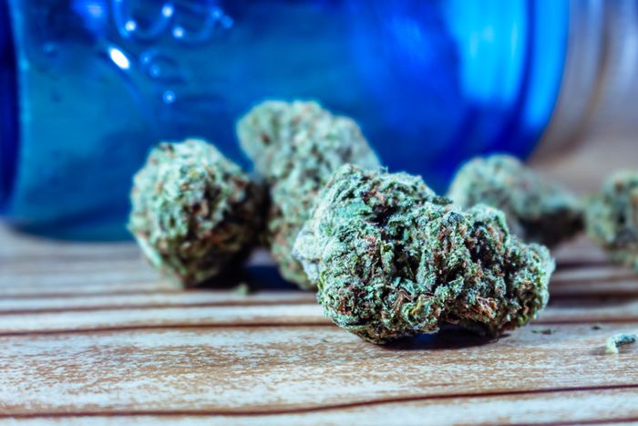 Dense cannabis nugs on a wooden surface